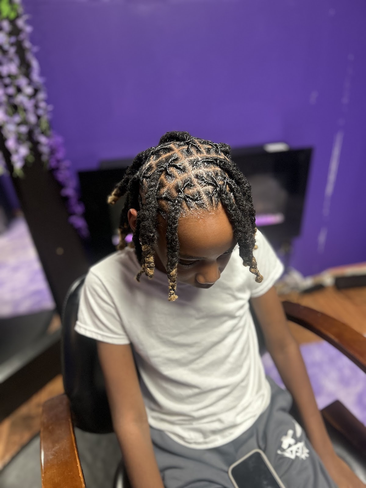 A young client with freshly styled starter locs